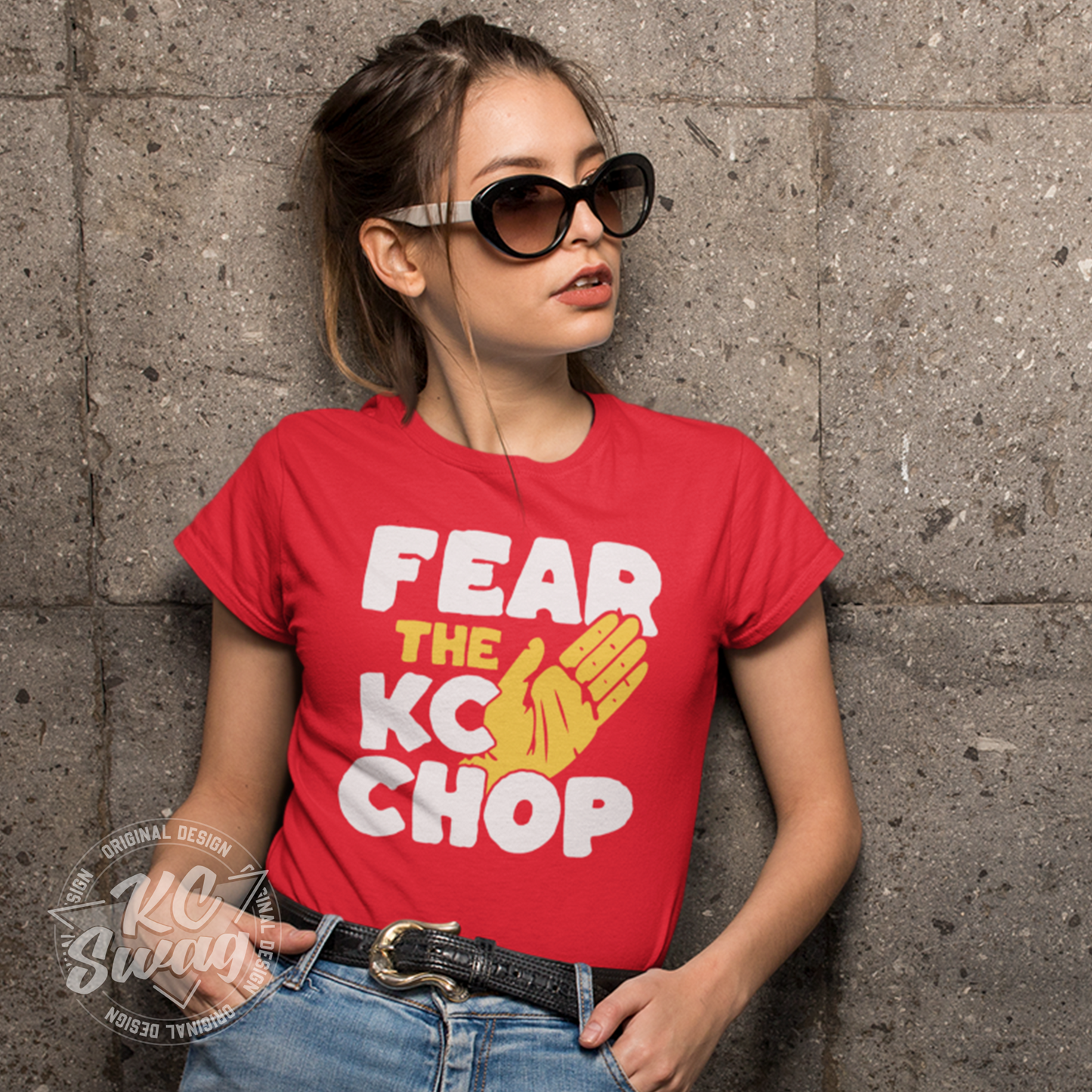 KC Swag - Kansas City Chiefs FEAR THE TOMAHAWK KC CHOP on red unisex t-shirt worn by female model wearing sunglasses and leaning on concrete wall