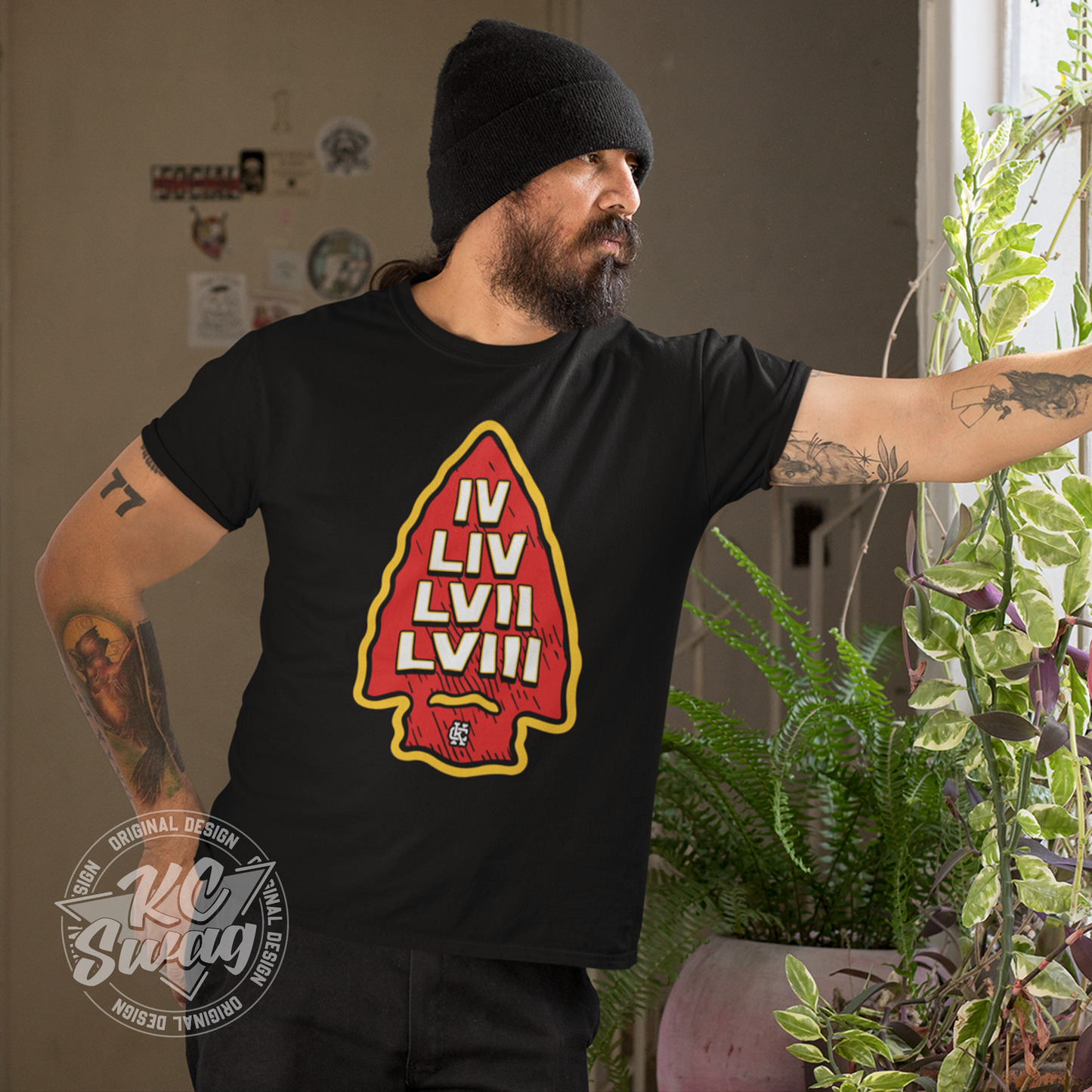 KC Swag - Kansas City Chiefs SUPER BOWL VICTORY ARROWHEAD on black unisex t-shirt worn by male modle looking out a home window surrounded by plants