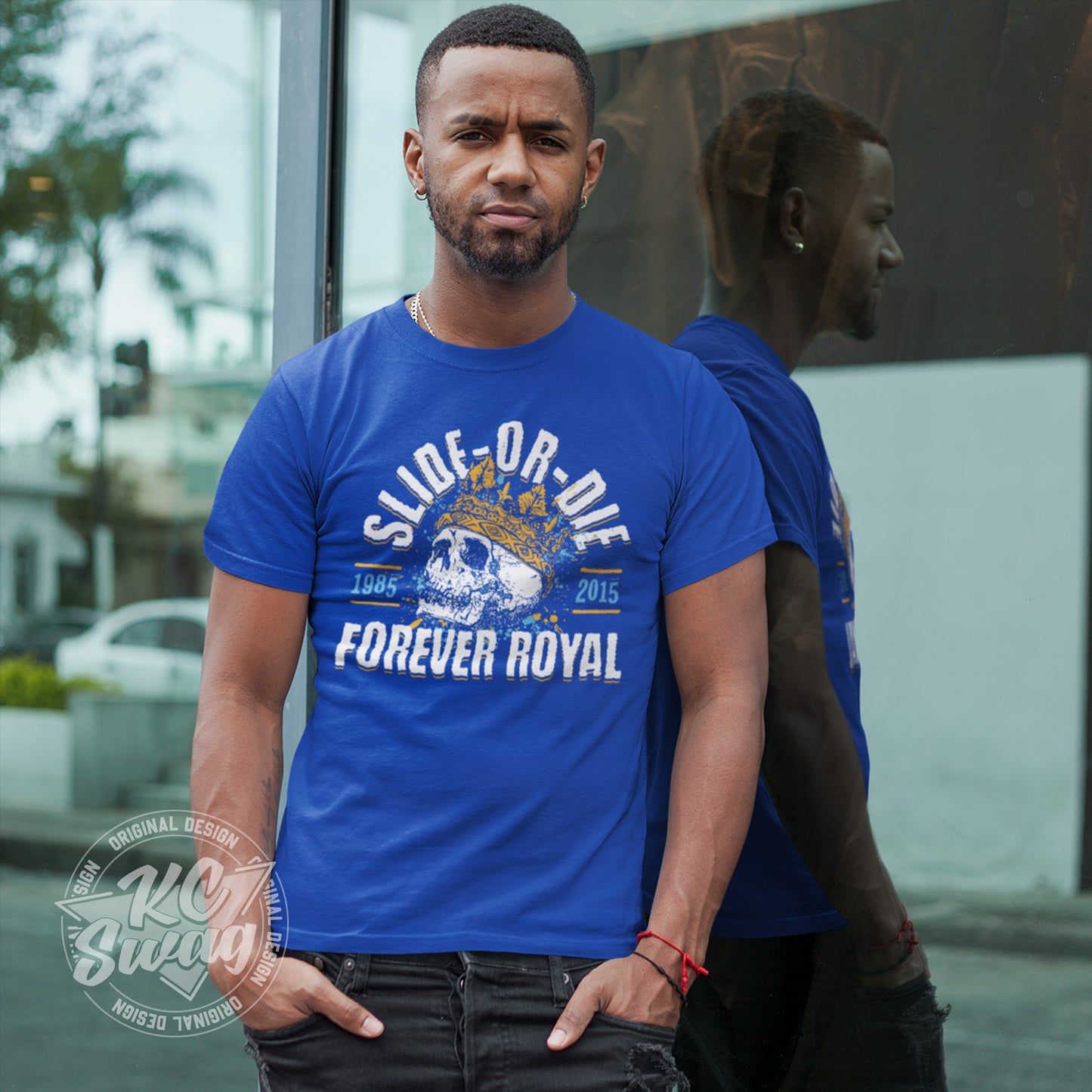 KC Swag - Kansas City Royals, Slide Or Die Forever Royal design on royal blue unisex t-shirt worn by male model leaing on windows outside of retail storefront