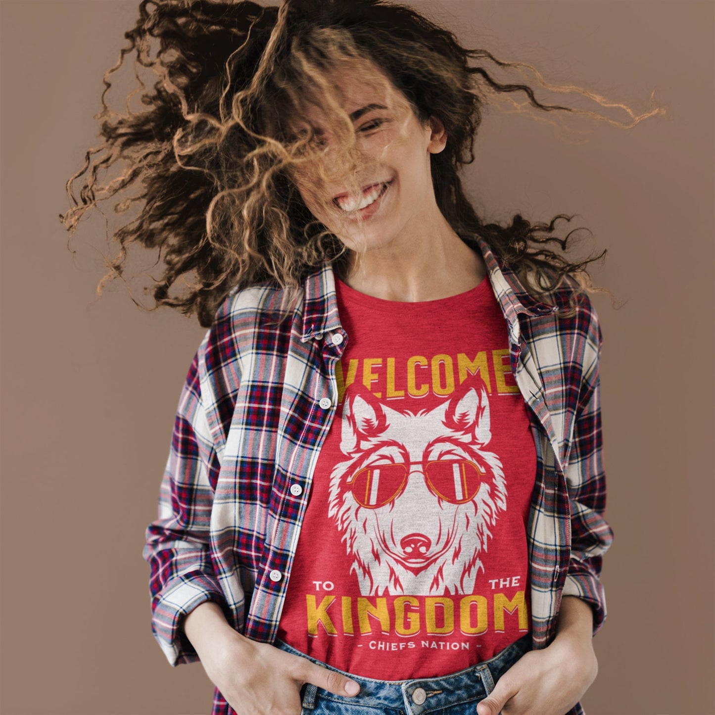 KC Swag Kansas City Chiefs COOL WOLF KINGDOM with wolf face graphic on heather red t-shirt worn by female model under an open plaid shirt