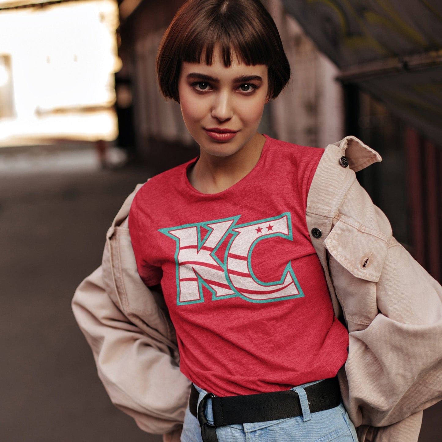 KC Swag Kansas City Current CURRENT KC on heather red unisex t-shirt worn by female model under canvas jacket in warehouse
