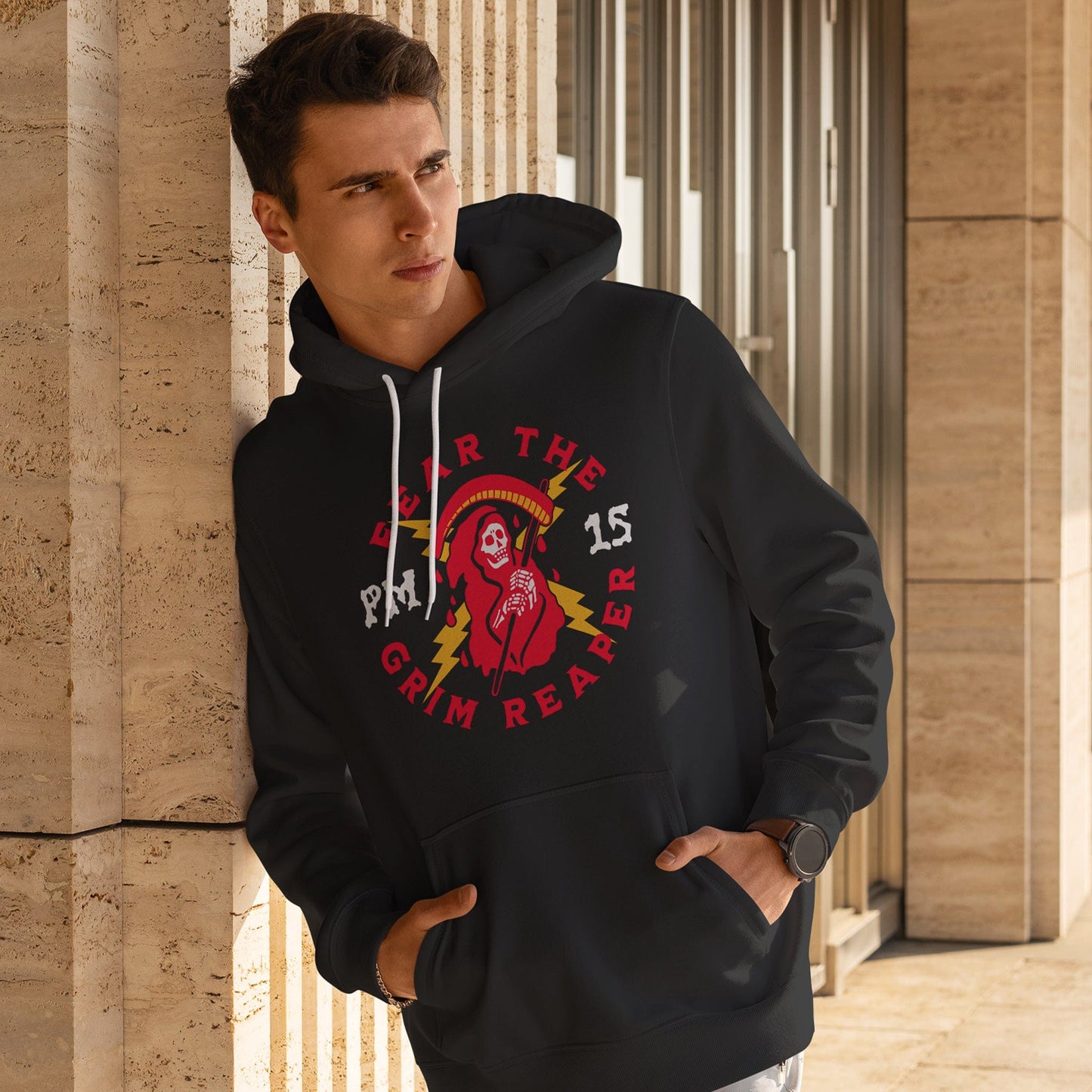 KC Swag Kansas City Chiefs GRIM REAPER PM15 on black fleece pull-over hoodie worn by male model leaning against concrete wall of building