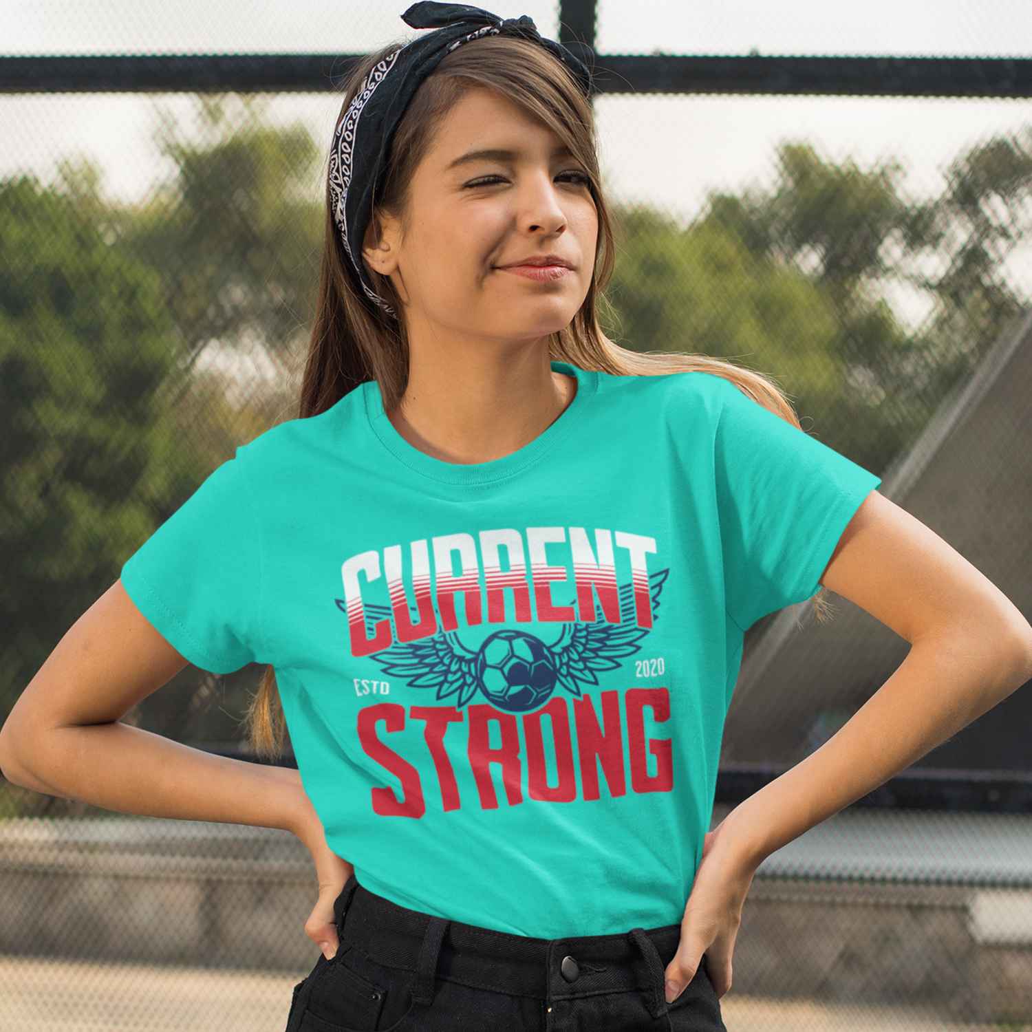 KC Swag Kansas City Current CURRENT STRONG on teal unisex t-shirt worn by female model in public park