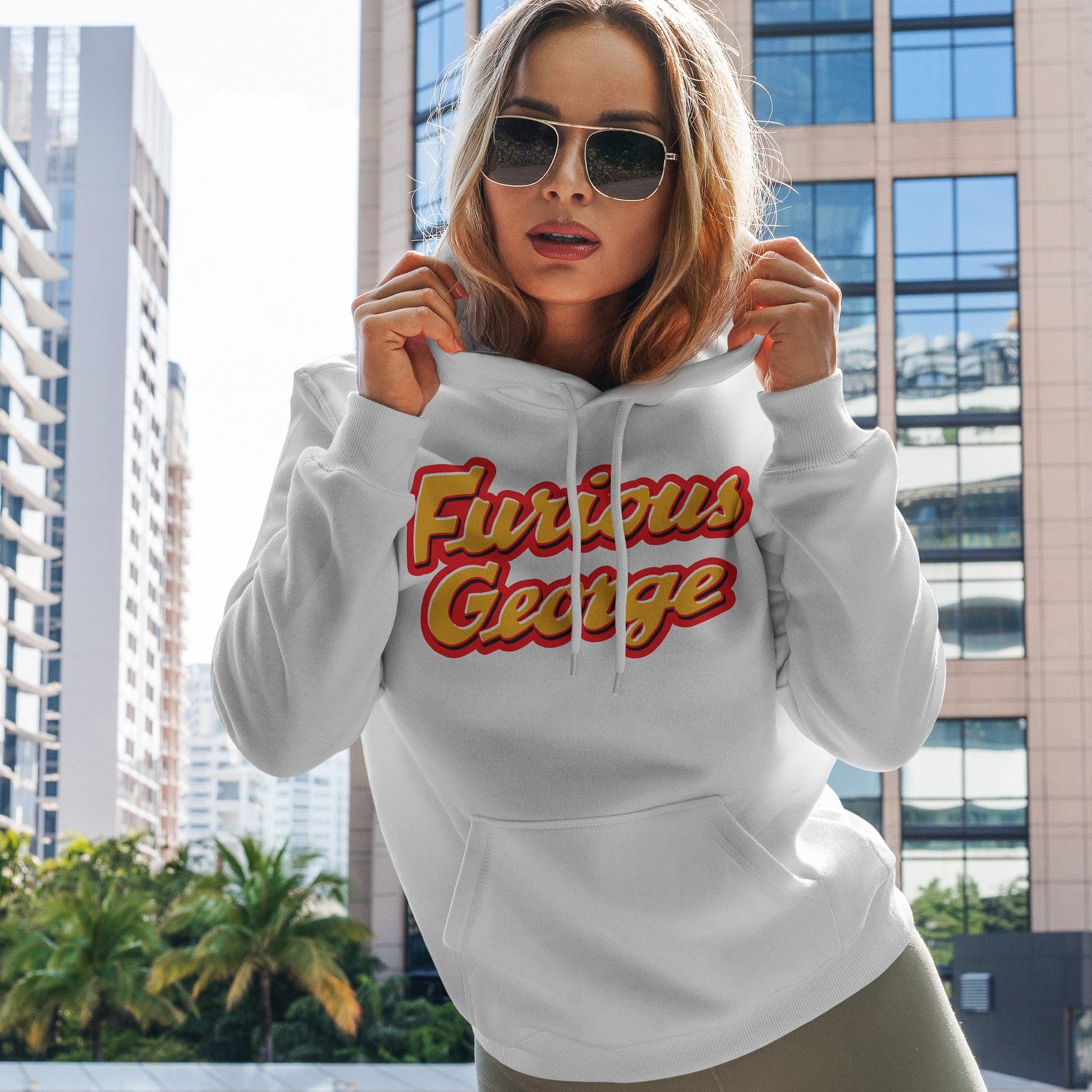 KC Swag | Kansas City Chiefs red/gold FURIOUS GEORGE on white sponge-fleece pullover hoodie worn by female model standing on balcony of downtown building