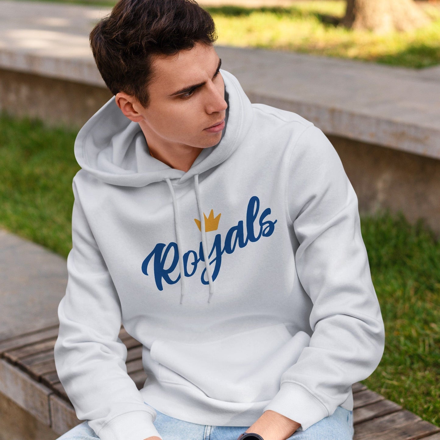 KC Swag | Kansas City Royals blue/gold FLOWER CROWN on white sponge-fleece pullover hoodie worn by male model sitting on bench in a public park