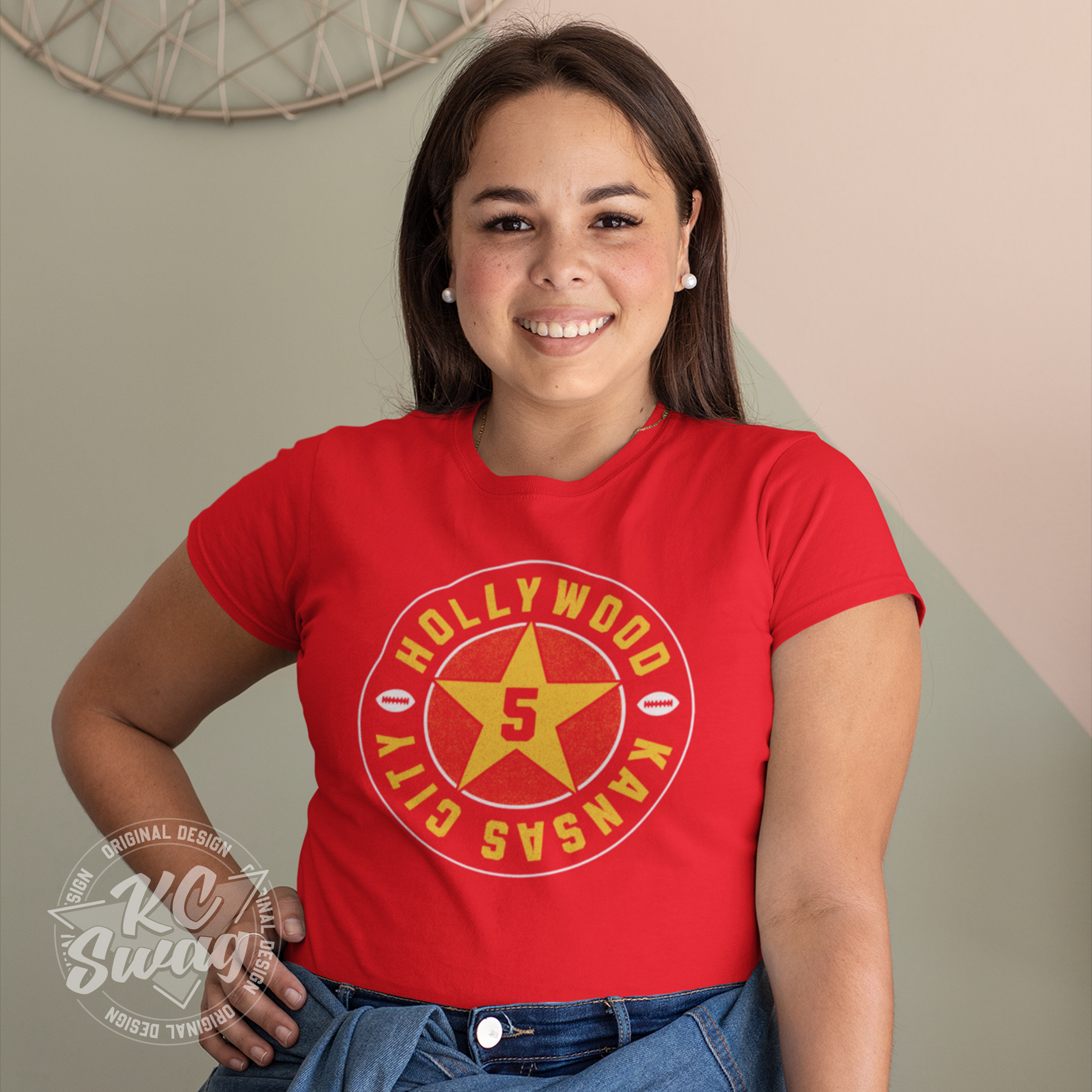 KC Swag - Kansas City Chiefs HOLLYWOOD BROWN STAR on red unisex t-shirt worn by female model standing in front of beige apartment wall