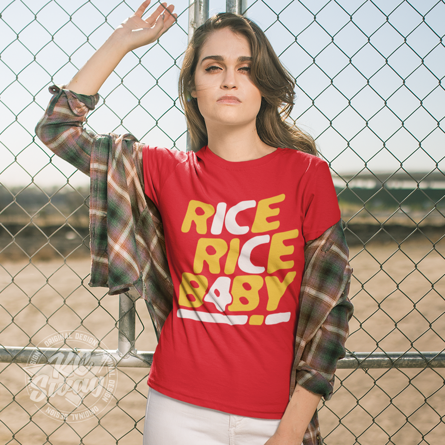 KC Swag - Kansas City Chiefs RICE RICE BABY KC 4 on red unisex t-shirt worn by female model leaning against a chainlink fence around construction zone