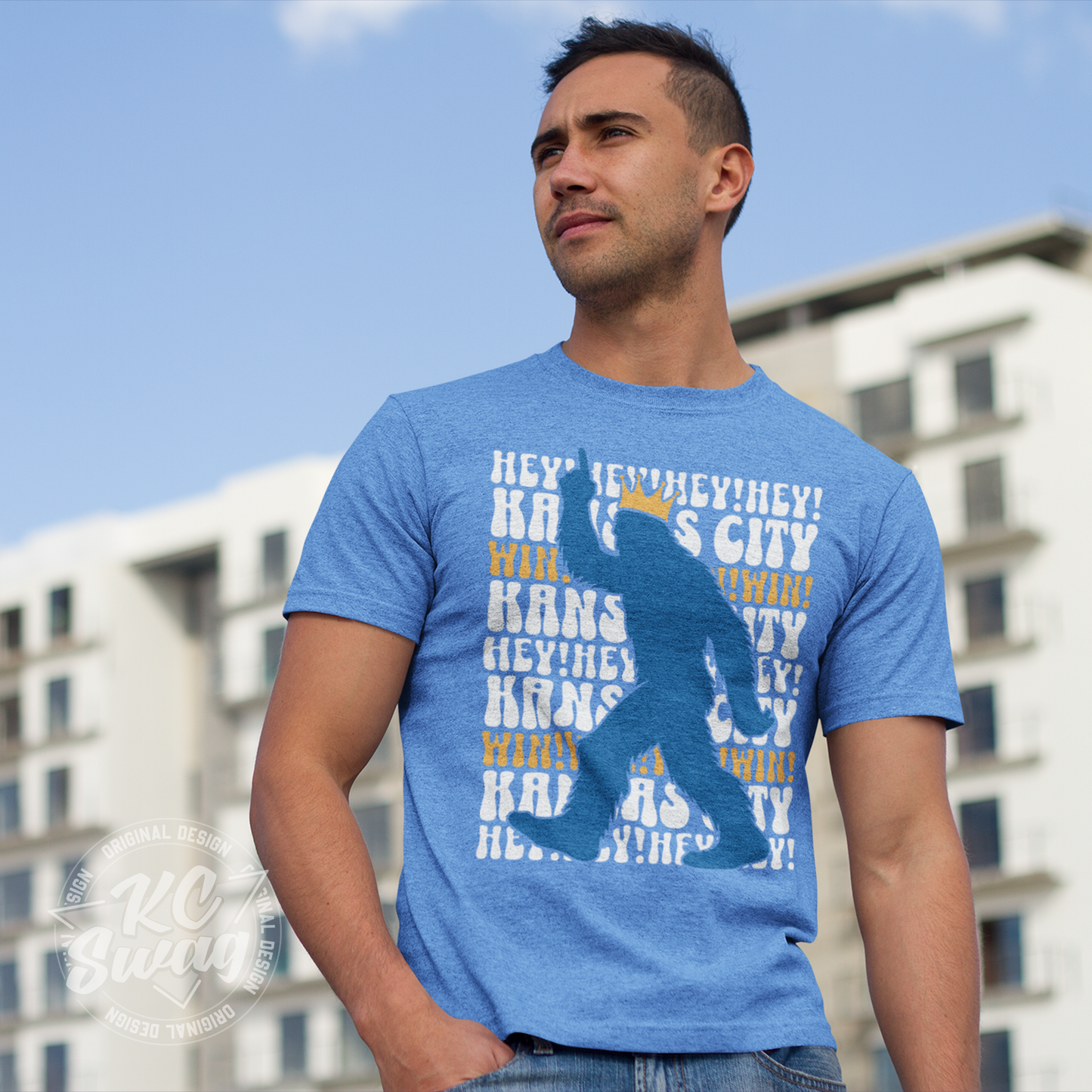 KC Swag - Kansas City Royals HEY HEY HEY PASQUATCH on a true heather columbia blue unisex t-shirt worn by male model standing in front of a large apartment building