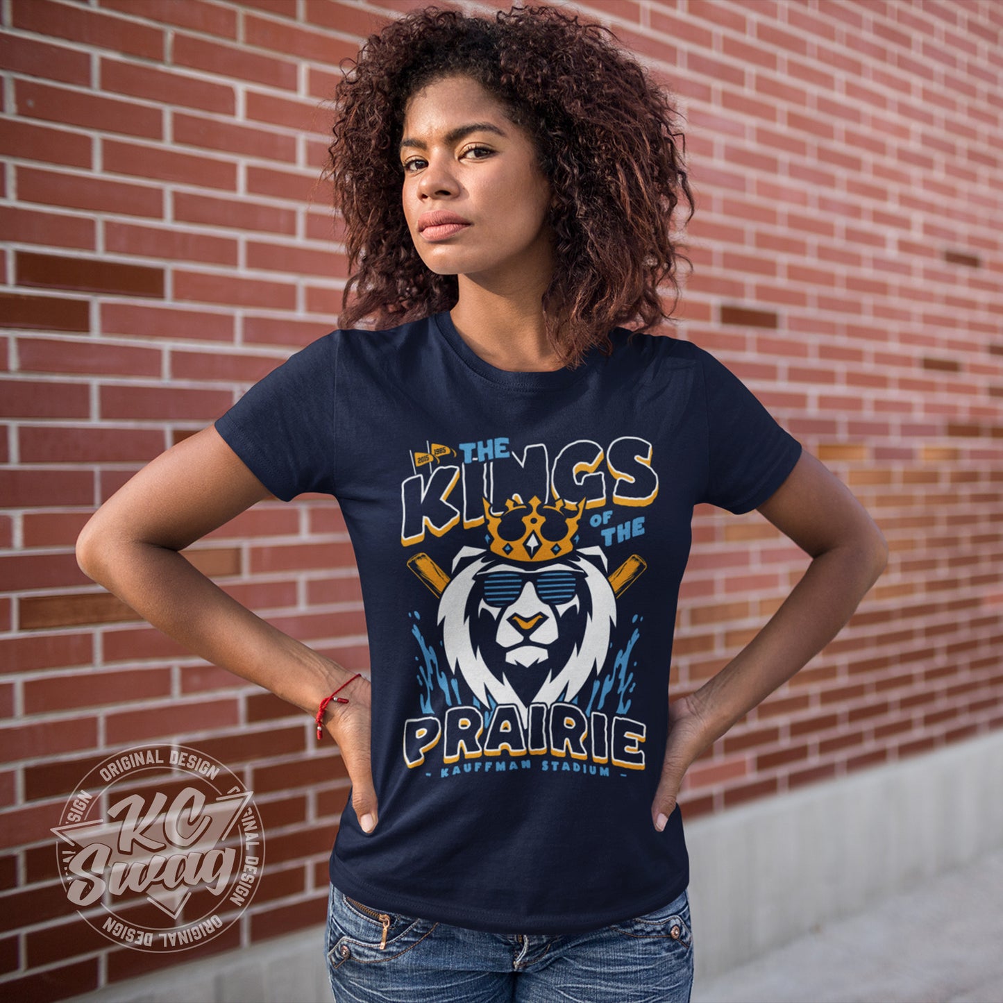 KC Swag - Kansas City Royals, Kings Of The Prairie design on navy blue unisex t-shirt worn by female model with her hands on her hips standing in front of a brick wall