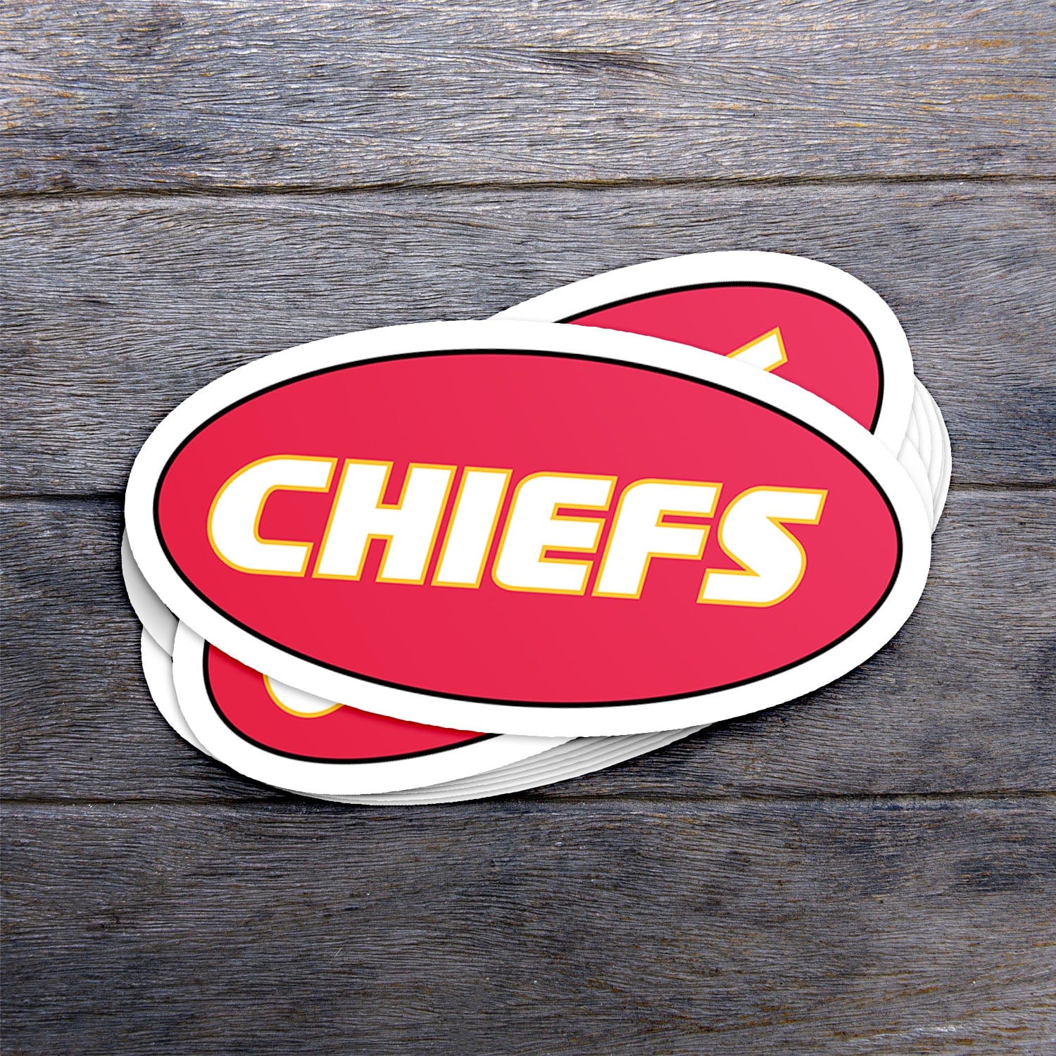 KC Swag Kansas City Chiefs red, yellow CHIEFS CLASSIC OVAL vinyl die cut decal sticker stack on dark wood table