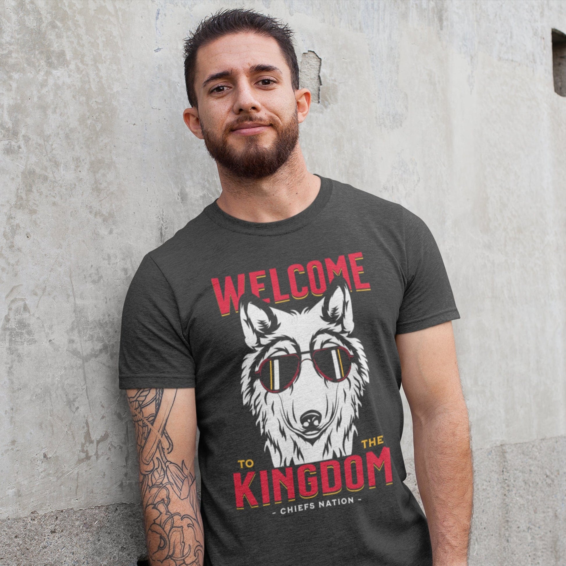 KC Swag Kansas City Chiefs COOL WOLF KINGDOM with wolf face graphic on dark heather grey t-shirt worn by bearded male model against concrete wall