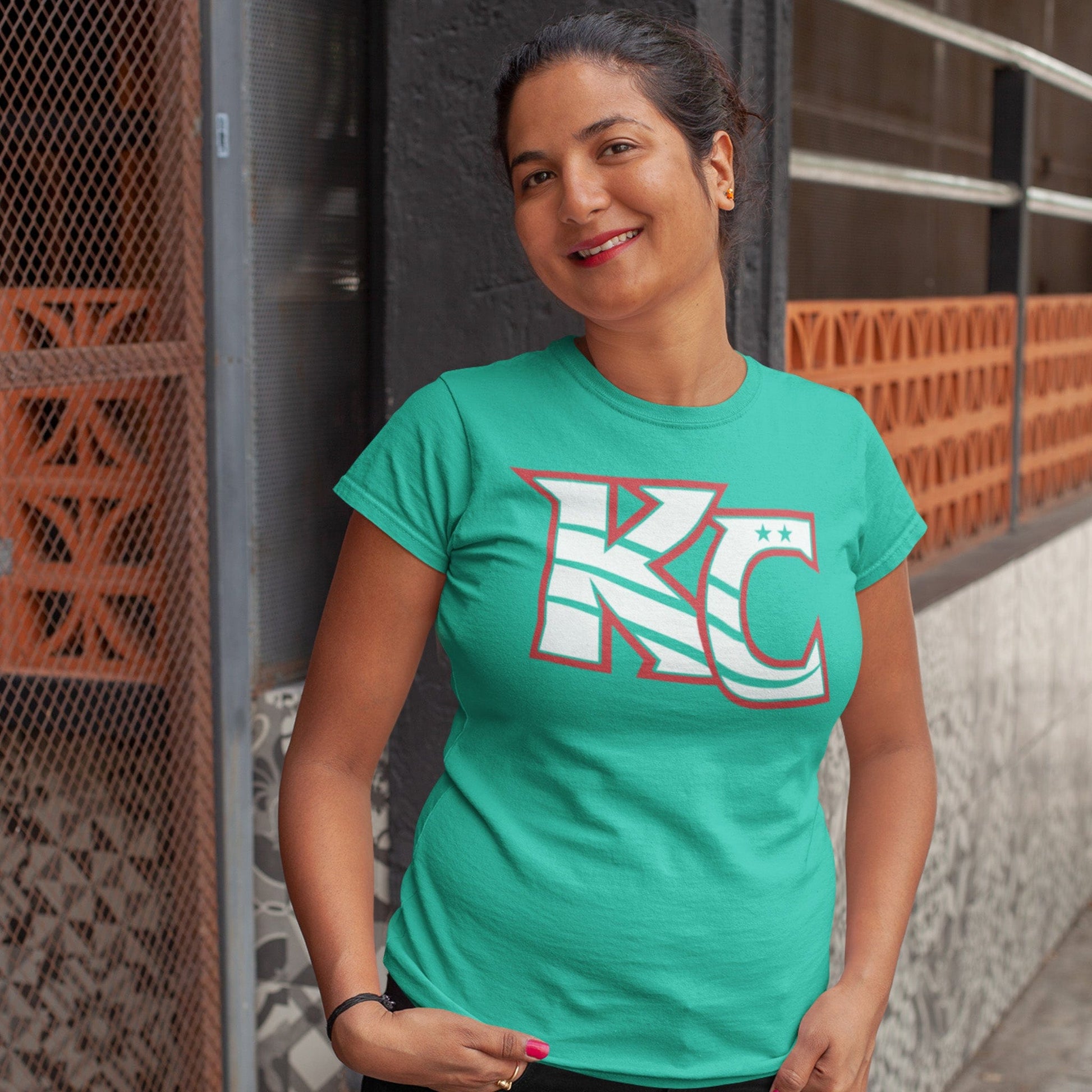 KC Swag Kansas City Current CURRENT KC on teal unisex t-shirt worn by female model standing outside downtown building