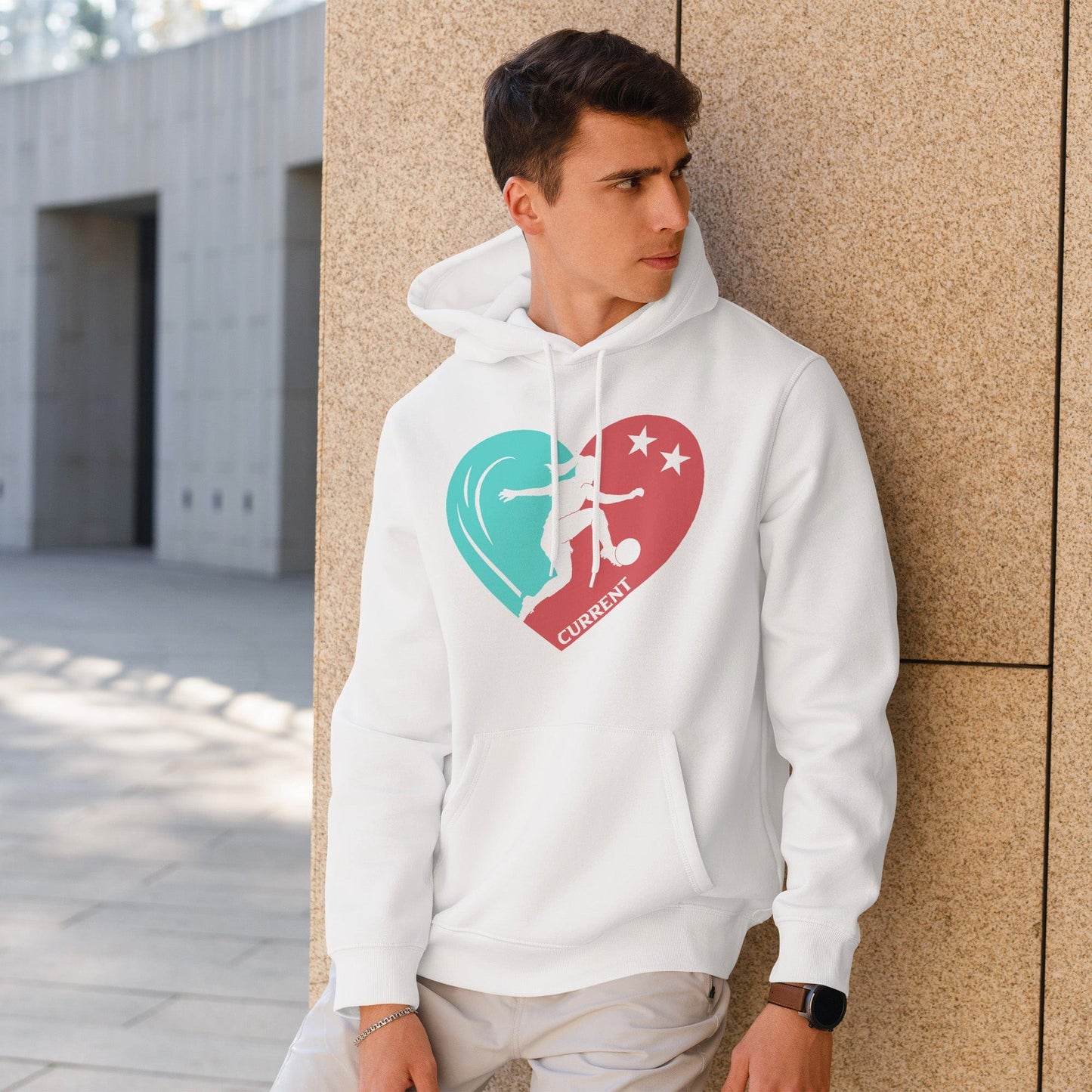 KC Swag Kansas City Current PLAYER HEART on white fleece pullover hoodie worn by male model leaning on stone wall in outdoor plaza
