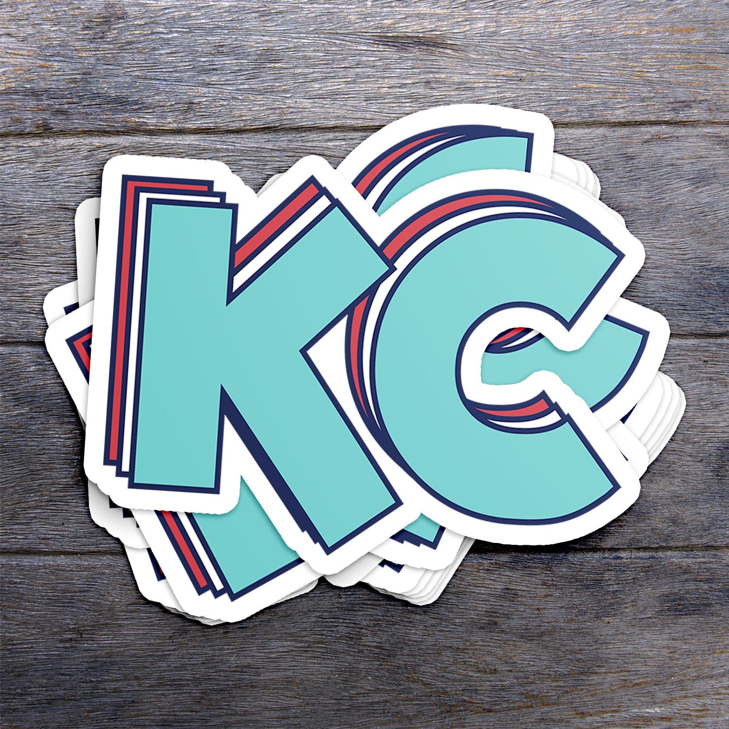 KC Swag Kansas City Current STACKED TEAL KC die-cut sticker decal made from waterproof vinyl stack on dark wood table