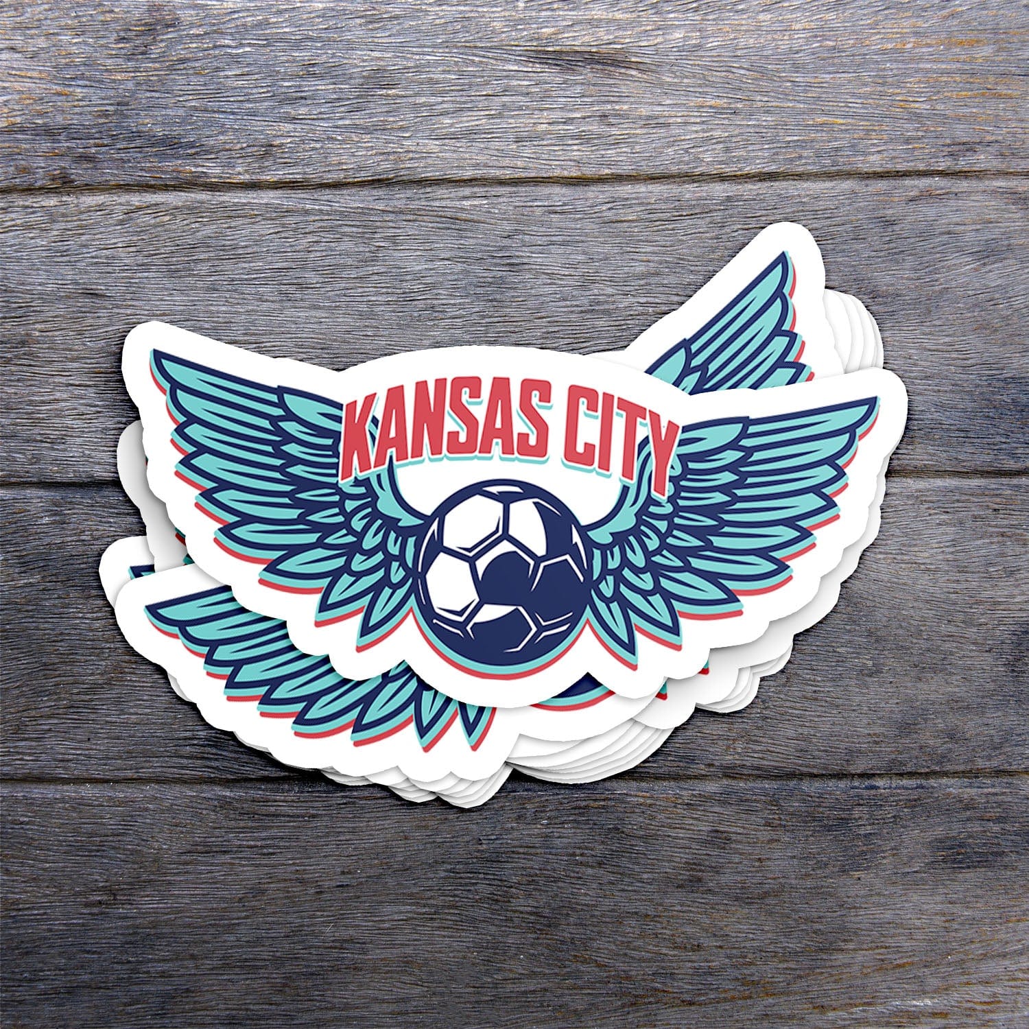 KC Swag Kansas City Current KC WING BALL die-cut sticker decal made from waterproof vinyl stack on dark wood table
