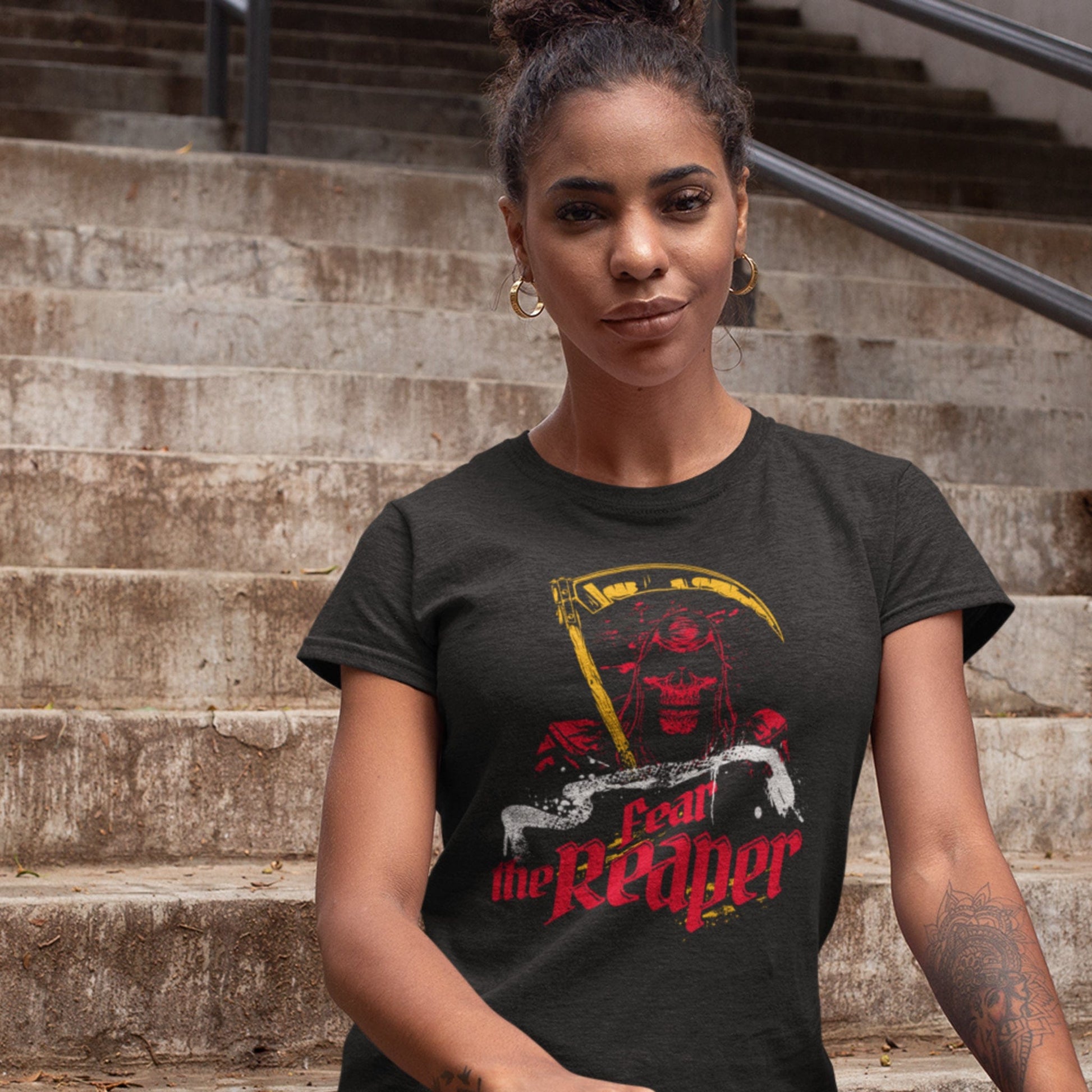 KC Swag Kansas City Chiefs COOL WOLF KINGDOM with wolf face graphic on dark heather grey t-shirt worn by female model sitting on concrete steps