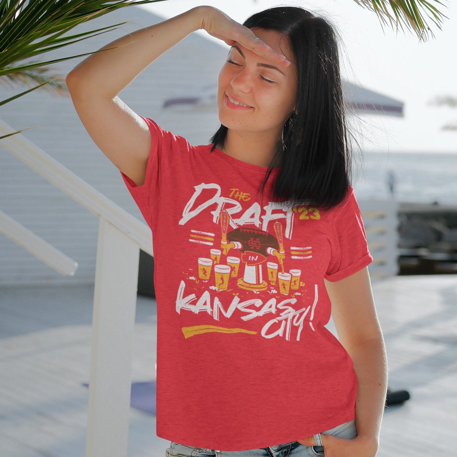 KC Swag Kanssas City Chiefs DRAFTIN' IN KC on heather red unisex t-shirt worn by female model standing on bright white deck