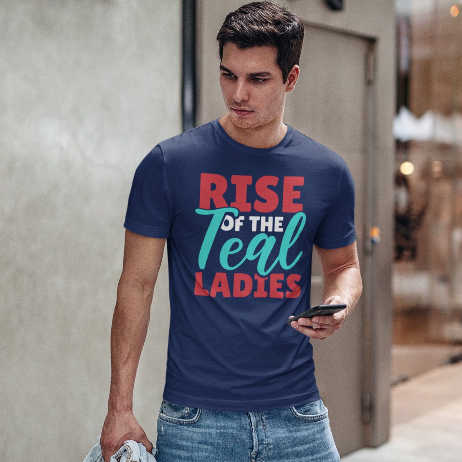 KC Swag Kansas City Current RISE OF THE TEAL LADIES on heather navy blue unisex t-shirt  worn by male model near stone wall