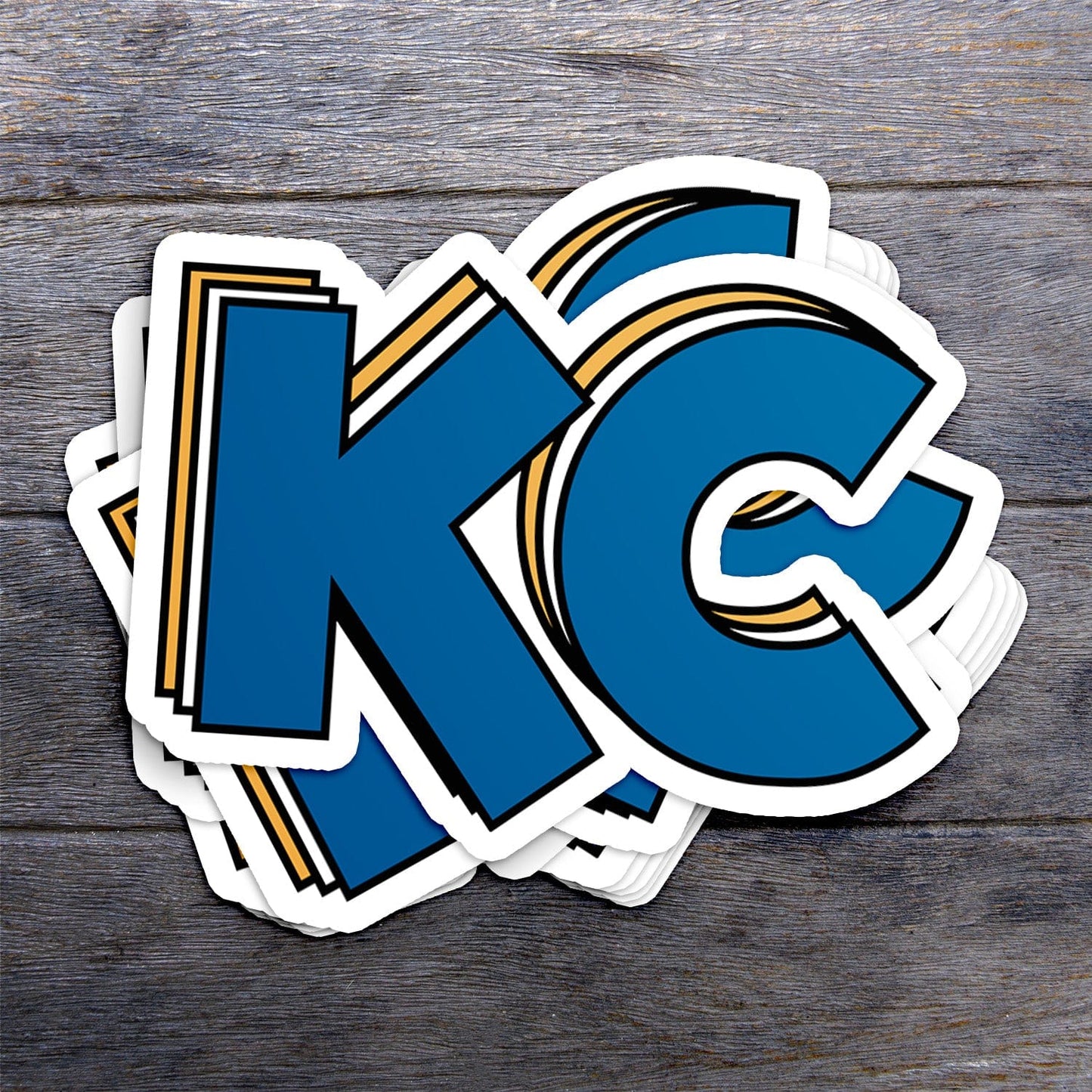 KC Swag Kansas City Royals blue, gold, white Stacked Blue KC vinyl die cut decal sticker stack on dark wood table