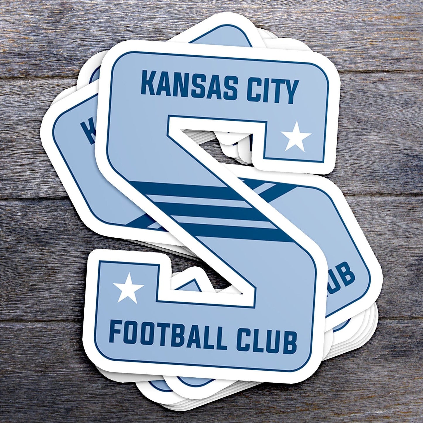 KC Swag Sporting Kansas City powder, navy, white KC Football Club S vinyl die cut decal sticker stack on dark wood stable