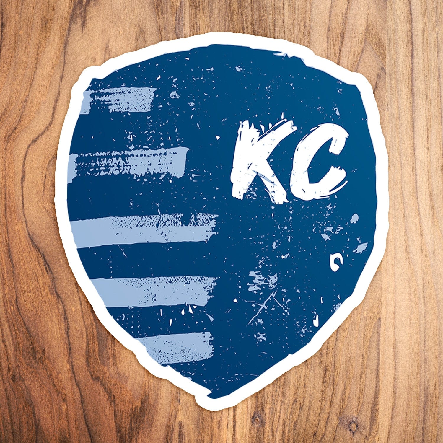 KC Swag Sporting Kansas City powder, navy, white Painted Shield vinyl die cut decal sticker on wood table