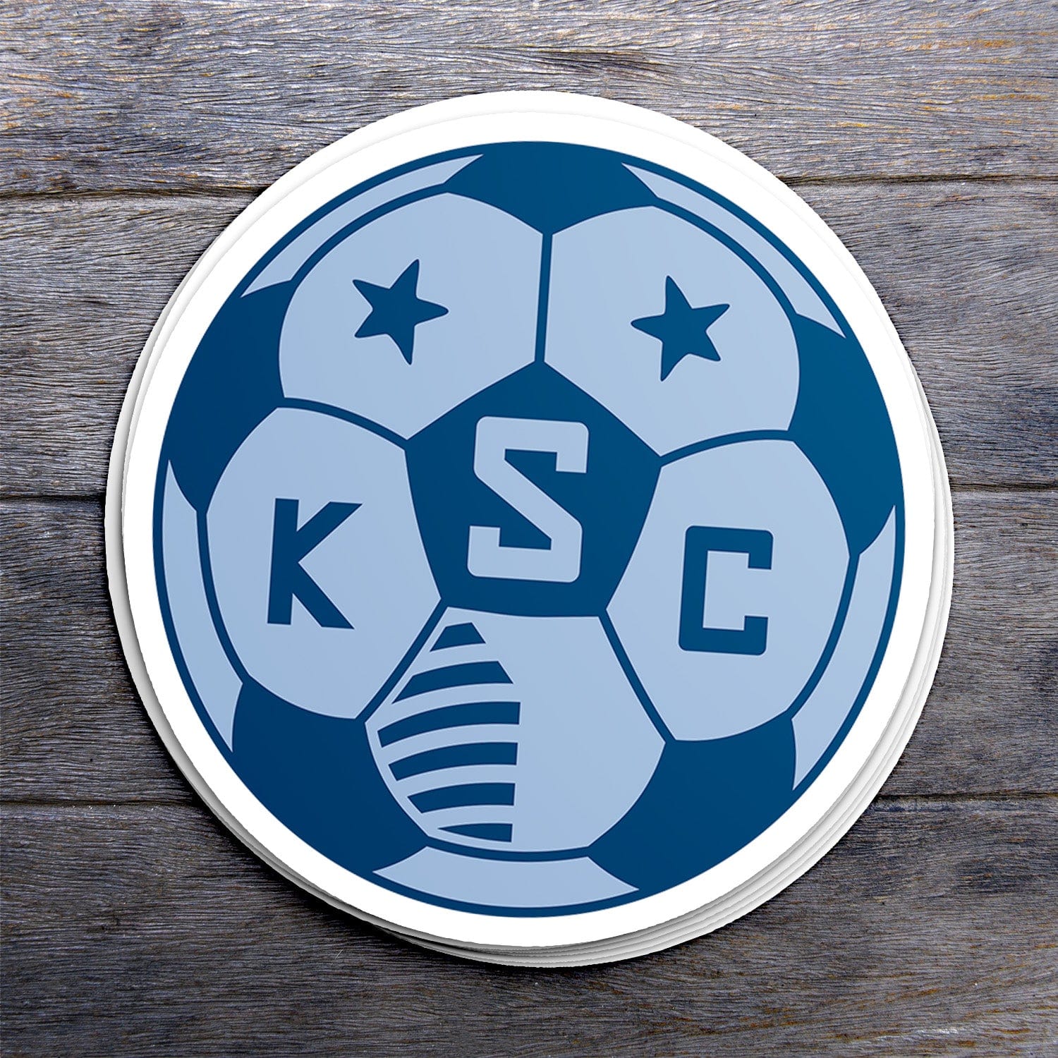 KC Swag Sporting Kansas City powder, navy, SKC Soccer Ball vinyl die cut decal sticker stack on dark wood table