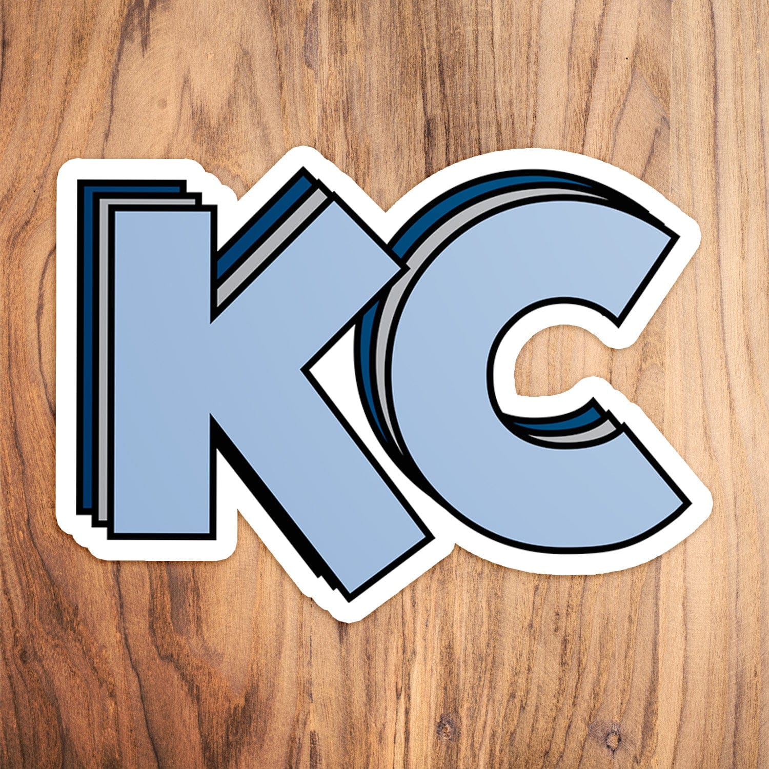 KC Swag Sporting Kansas City powder, silver, navy Stacked Powder KC vinyl die cut decal sticker on wood table